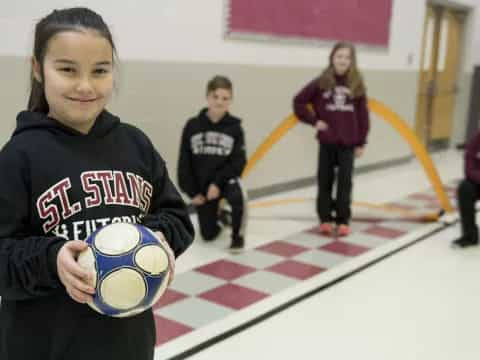 a group of children playing with a football ball