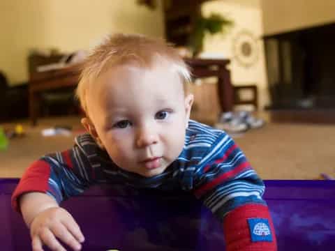 a baby sitting on a purple chair
