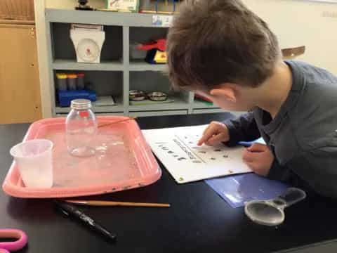 a boy writing on a piece of paper