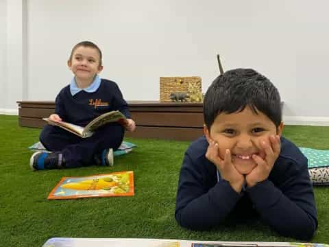 a couple of boys sitting on the floor reading books
