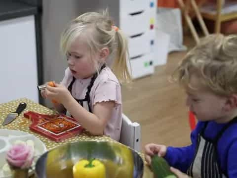 a couple of children playing with a bowl of food