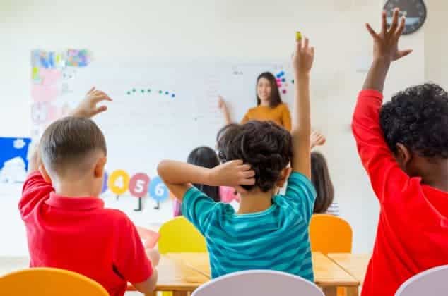 a group of children raising their hands