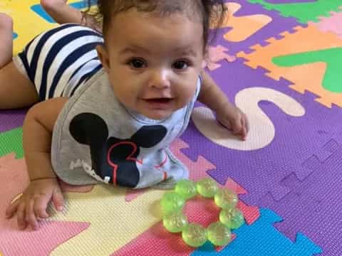 a baby lying on a colorful blanket