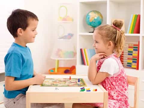a boy and girl playing a board game