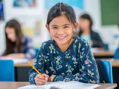 a young girl sitting at a desk