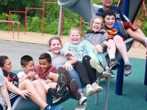 a group of kids sitting on a slide