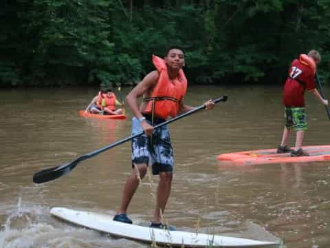 a group of people paddle kayaks