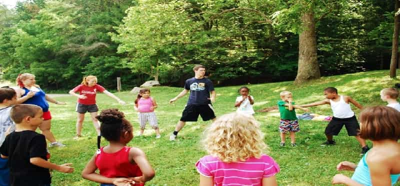 a group of children playing in a grassy field