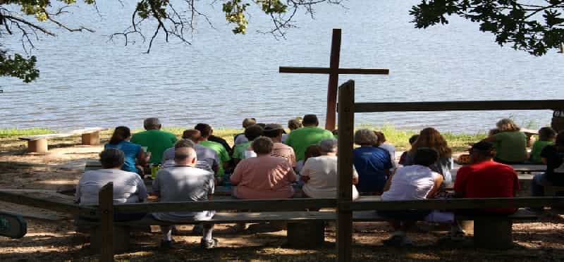 a group of people sitting on a bench by a body of water