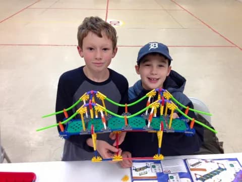 two boys holding a model airplane