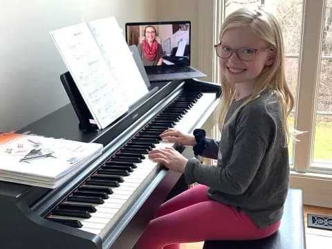 a girl sitting at a piano