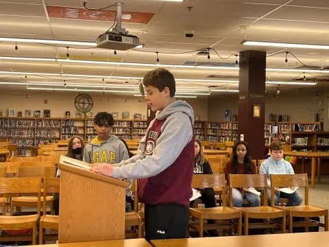 a boy standing in a classroom
