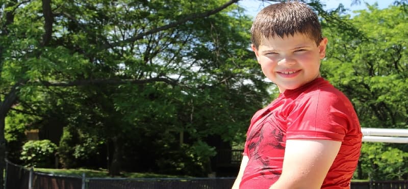 a boy smiling outside