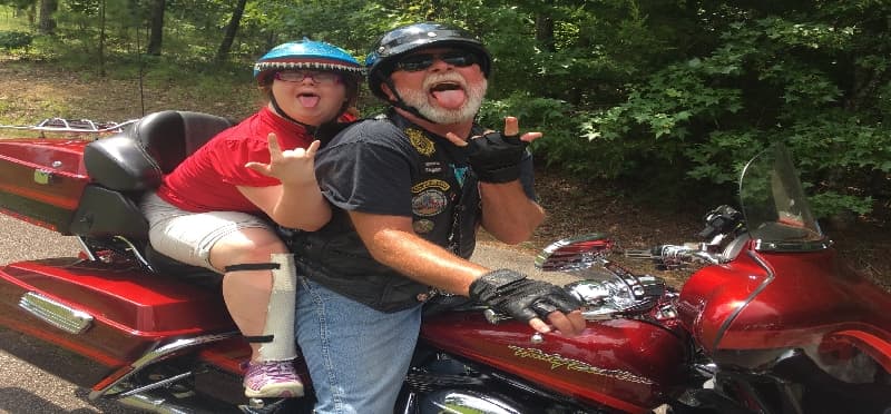 a person and a child on a red motorcycle