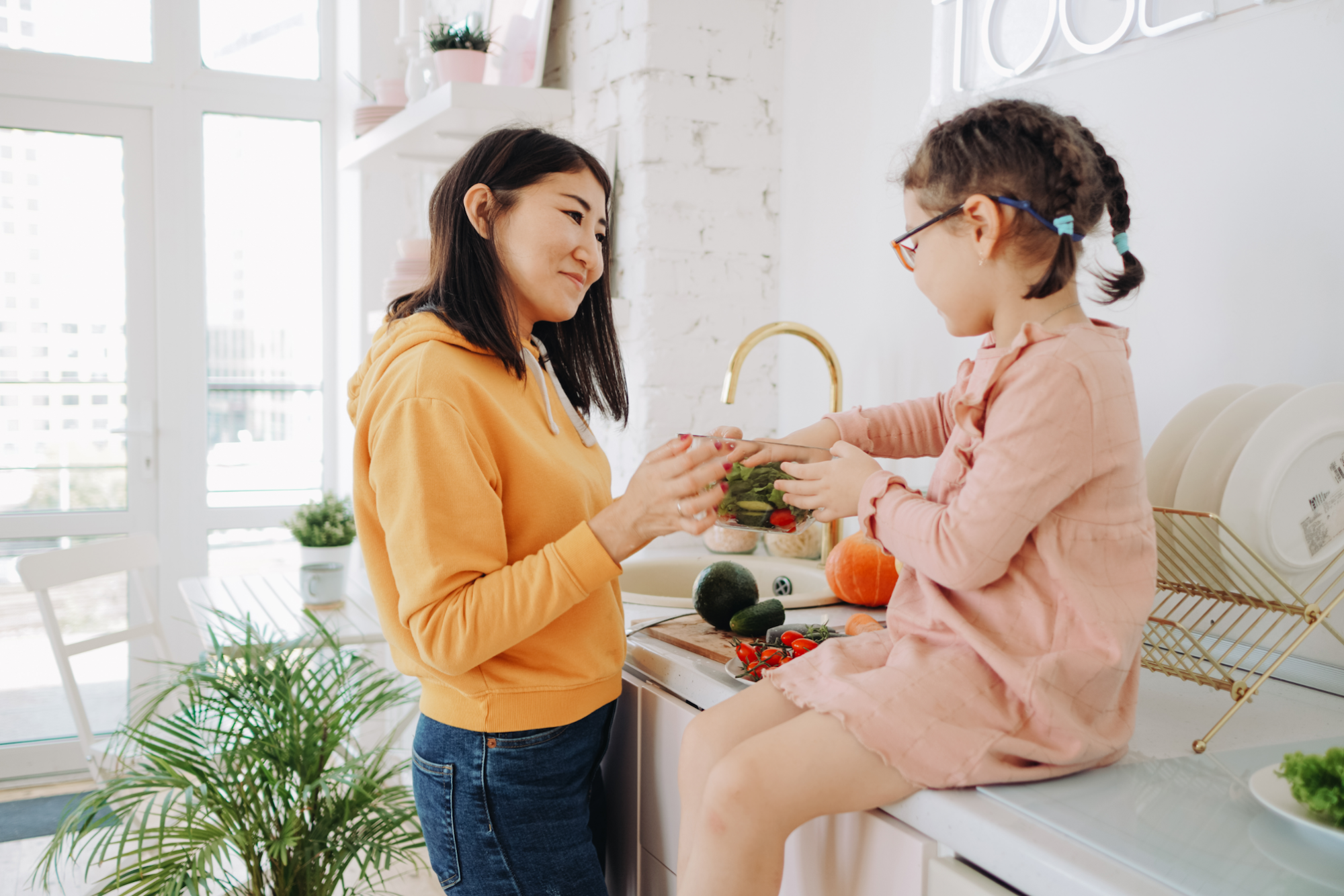 a person and a girl holding vegetables