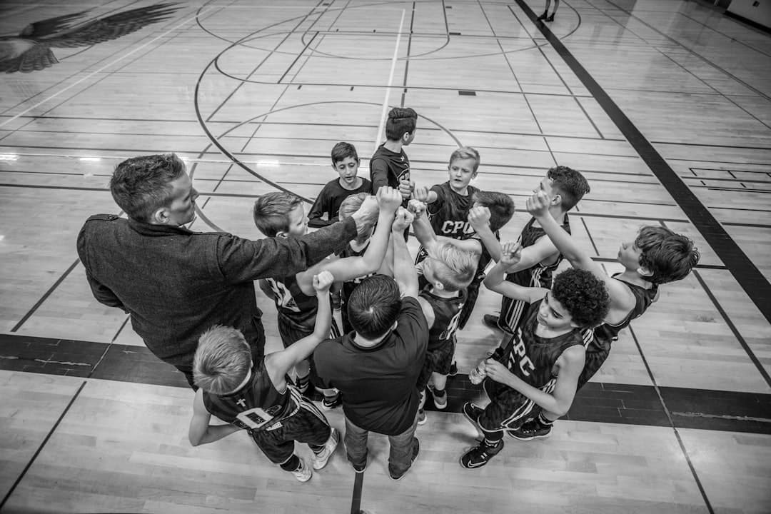 grayscale photography of boys raising hand