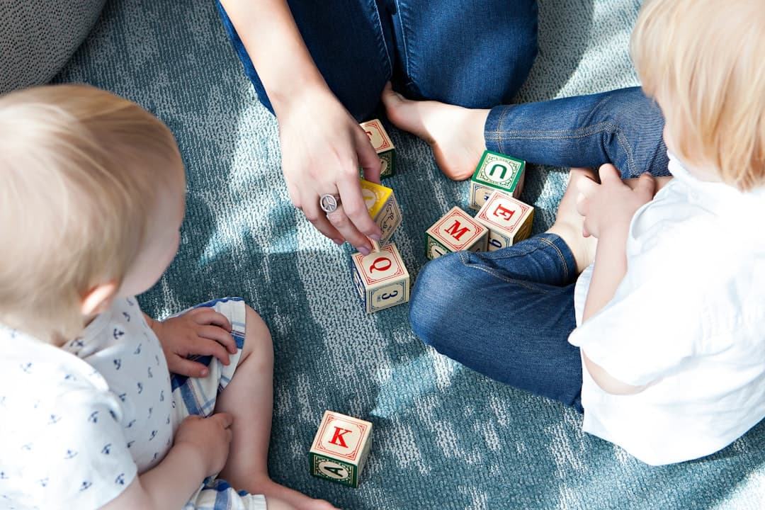 two toddler playing letter cubes