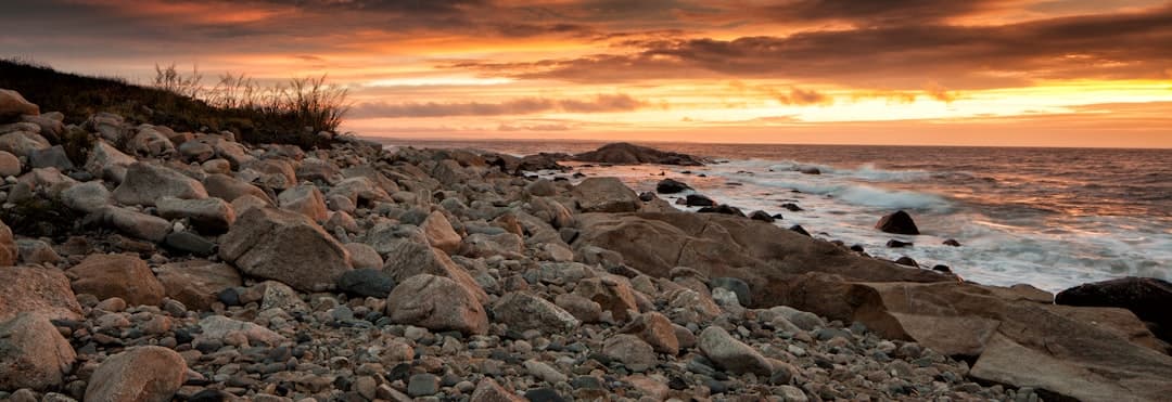 a rocky beach with waves crashing on the shore