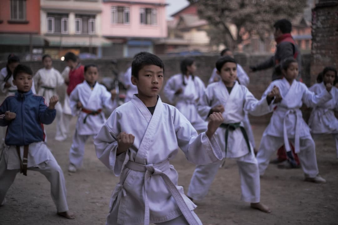 boy in white robe holding a stick