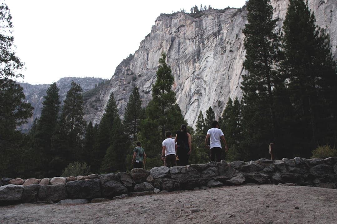 people standing on rocky ground near mountain during daytime