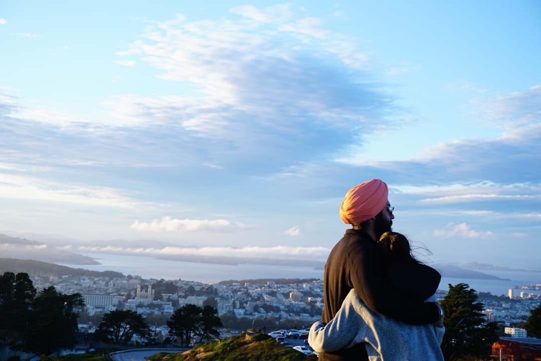 woman in black jacket and pink knit cap looking at city during daytime