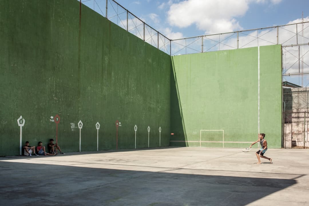 a young boy is playing tennis on a concrete court