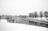 a snowy landscape with trees and a river