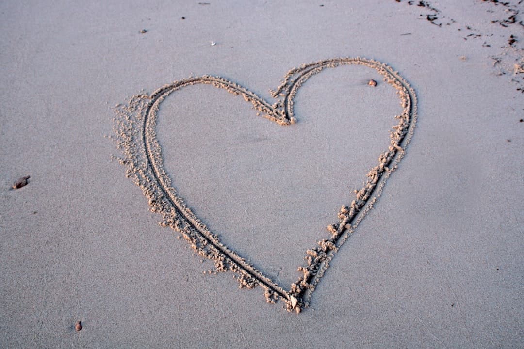 a heart drawn in the sand on a beach