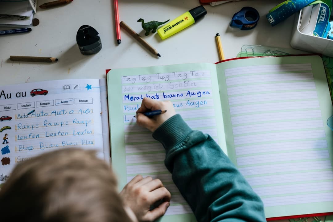 a person writing on a notebook with a pen