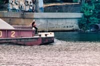 a man riding on the back of a boat in the water