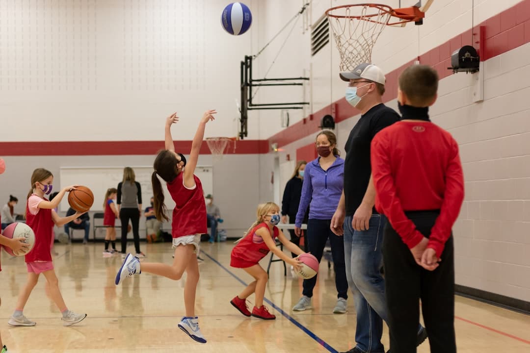 a group of young children playing a game of basketball