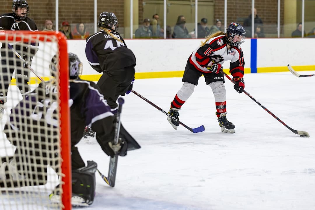 a group of people playing a game of ice hockey