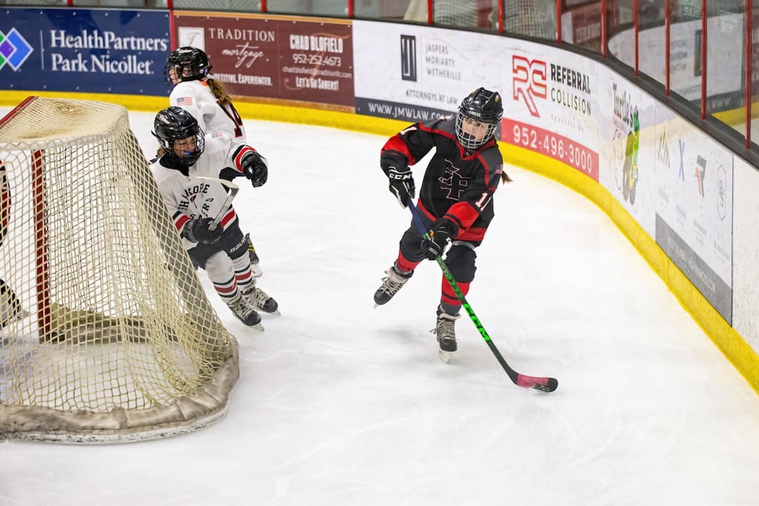 a couple of kids playing a game of ice hockey