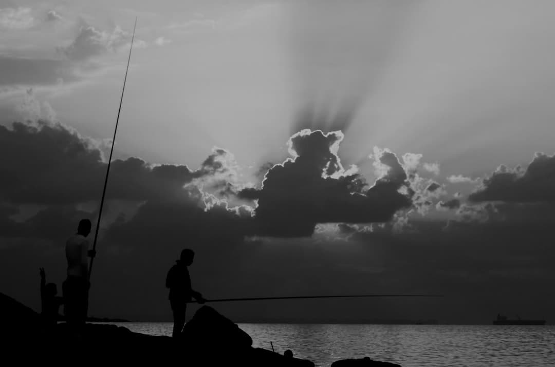 a couple of men standing next to a body of water