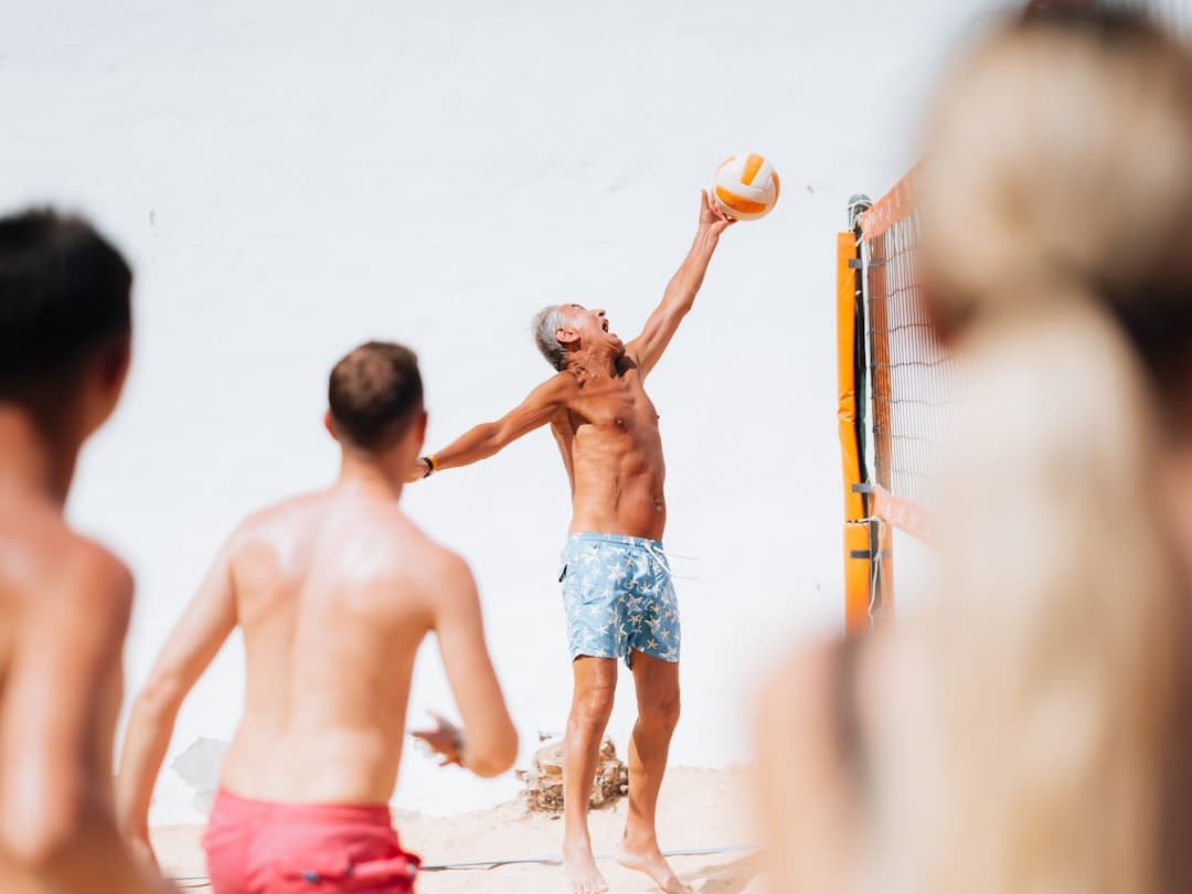 A group of people playing volleyball on the beach