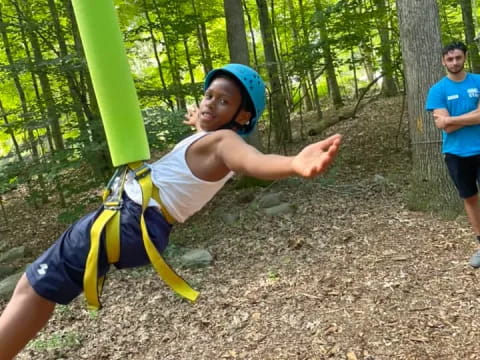 a boy in a harness in the woods