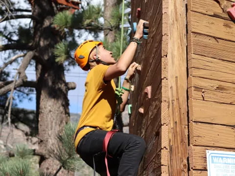 a person wearing a helmet and climbing a wooden wall