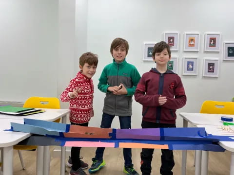 a group of boys standing in a classroom