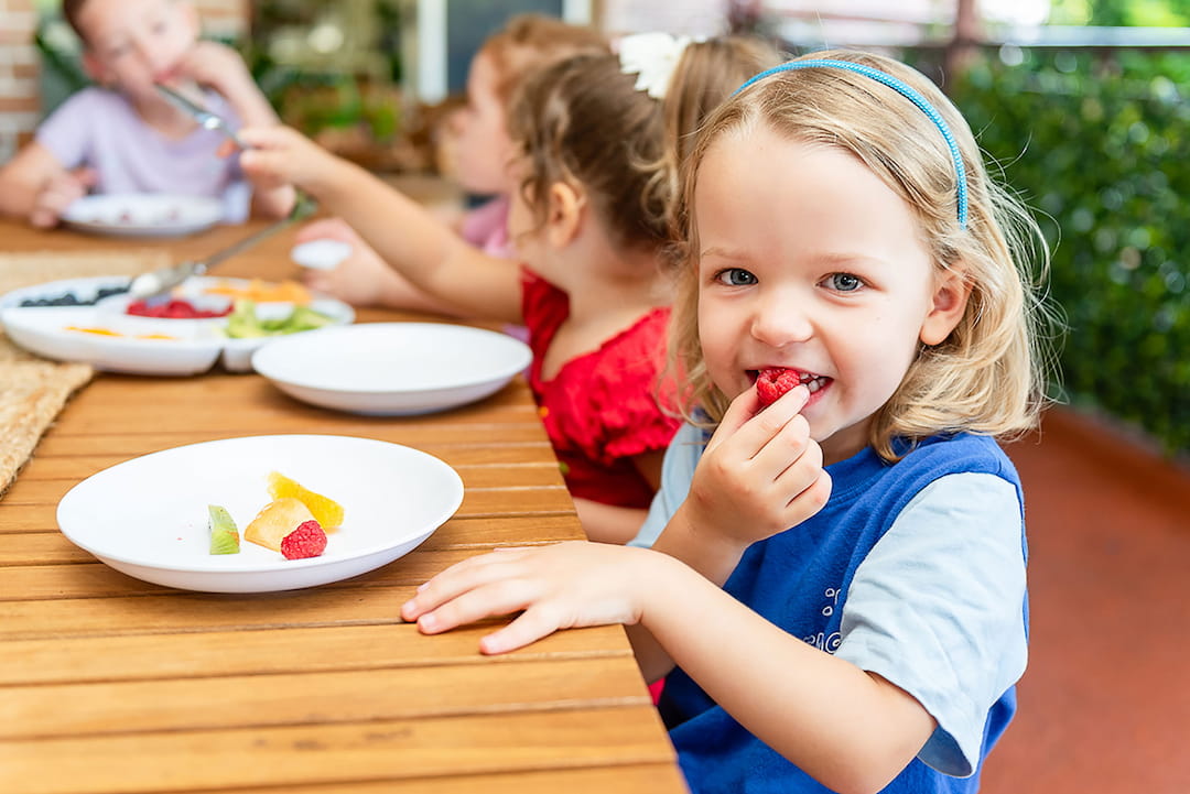 a group of children eating at a table