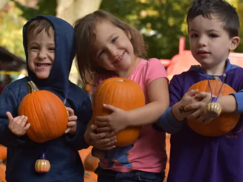 a group of children holding pumpkins