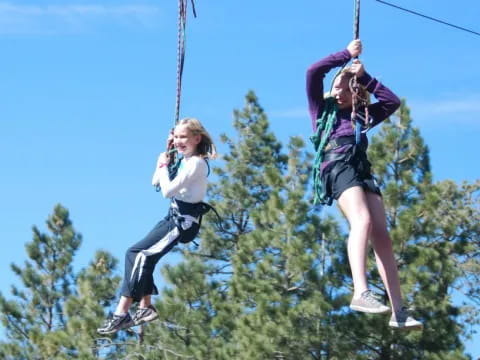 a couple of girls on a swing