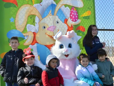 a group of people posing with a person in a rabbit garment