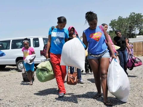 a group of people carrying bags