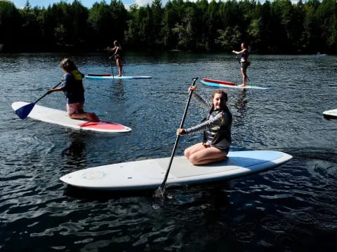 a group of people paddle on surfboards