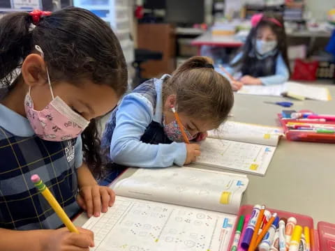 a few children writing on paper