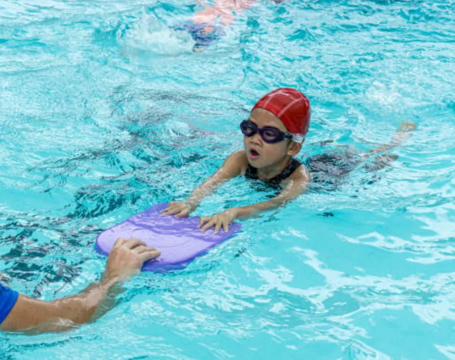 a person in a pool with a dolphin