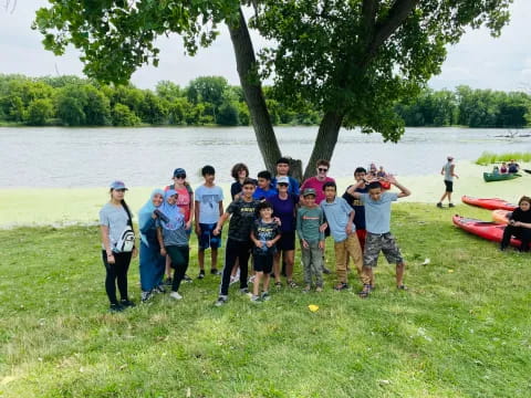 a group of people standing by a body of water