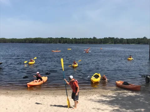 a group of people in kayaks on a beach