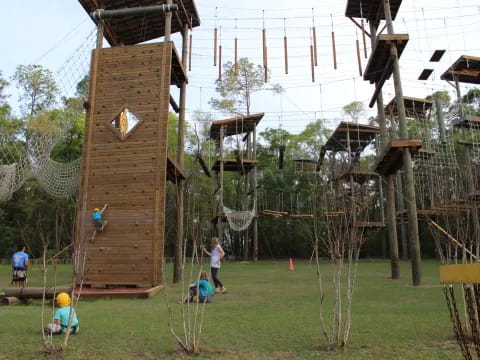 a group of people playing in a yard with a wooden structure