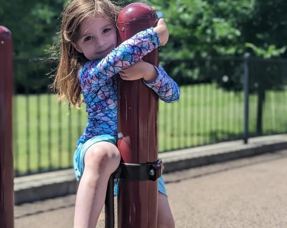 a girl sitting on a pole